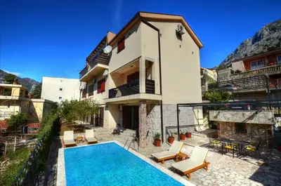a house with a swimming pool next to a building at DC Apartment D in Kotor