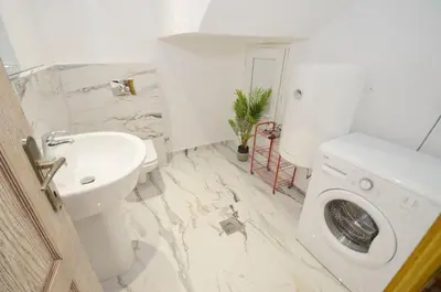 a bathroom with a sink and a washing machine at DC Apartment D in Kotor