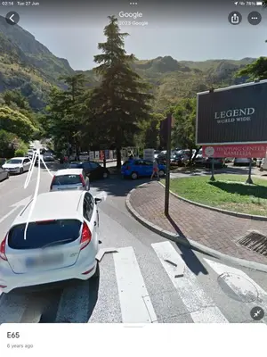 a white car is parked at a cross walk at DC Apartment D in Kotor