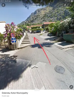 a red arrow on a street with a mountain at DC Apartment D in Kotor