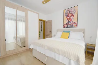 a bedroom with a bed with a painting on the wall at DC Apartment C in Kotor