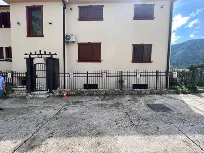 a building with brown doors and a fence at DC Apartment C in Kotor
