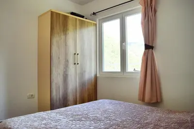 a bedroom with a bed and a window and a dresser at Apartments Nikčević in Budva
