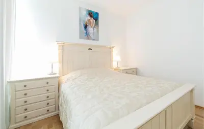 a white bedroom with a bed and two dressers at Nice Home In Kotor With Sauna in Kotor