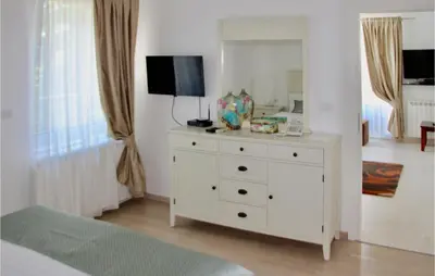 a bedroom with a white dresser with a mirror at Nice Home In Kotor With Sauna in Kotor