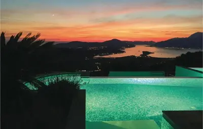 a swimming pool with a sunset in the background at Nice Home In Kotor With Sauna in Kotor