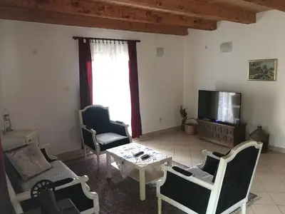 a living room with chairs and a table and a tv at Milovan in Cetinje