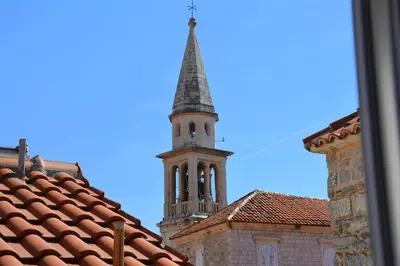 a tall tower with a steeple on top of a building at Montenegro Backpackers Home Budva in Budva