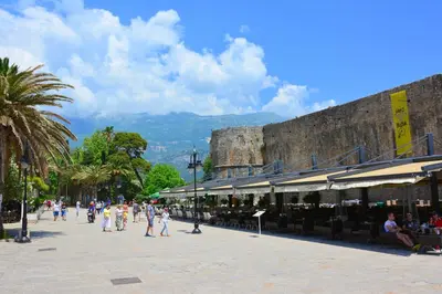a group of people walking on a street near a building at Montenegro Backpackers Home Budva in Budva