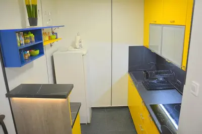 a small kitchen with yellow cabinets and a sink at Montenegro Backpackers Home Budva in Budva