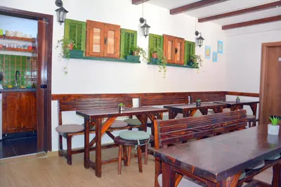 a restaurant with wooden tables and chairs in a room at Montenegro Backpackers Home Kotor in Kotor