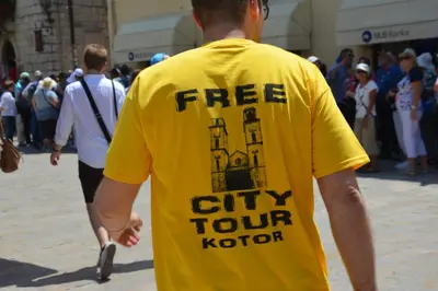 a man wearing a yellow shirt with the words free city tourachi at Montenegro Backpackers Home Kotor in Kotor
