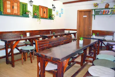 a restaurant with wooden tables and chairs in a room at Montenegro Backpackers Home Kotor in Kotor