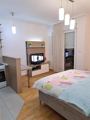 a bedroom with a bed and a tv in it at Apartment Bono 2 City Kvart in Podgorica