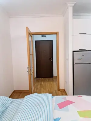 a bedroom with a bed and a door to a closet at Apartment Bono 2 City Kvart in Podgorica
