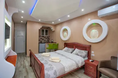 a bedroom with a large bed and two circular windows at Apartments Bella Vista in Kotor