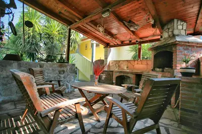 a patio with a table and chairs and a fireplace at Apartments Bella Vista in Kotor