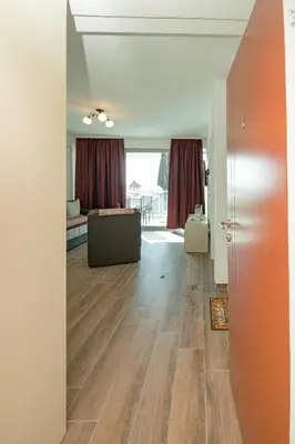 a living room with wood floors and a room with a couch at Celebrity Style Lux Apartment in Bar