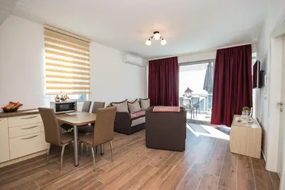 a kitchen and living room with a table and a couch at Celebrity Style Lux Apartment in Bar
