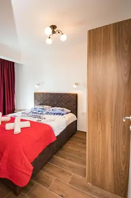 a bedroom with a large bed with a red blanket at Celebrity Style Lux Apartment in Bar