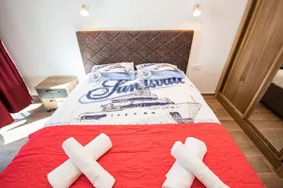 a bed with two crossed towels on top of it at Celebrity Style Lux Apartment in Bar