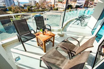 a balcony with chairs and a table on a boat at Celebrity Style Lux Apartment in Bar