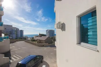 a car parked in a parking lot next to a building at Celebrity Style Lux Apartment in Bar