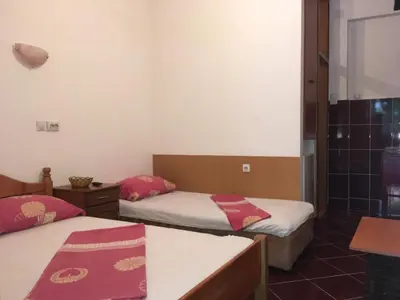 a room with two beds with red pillows at Apartmani Vuković in Sutomore
