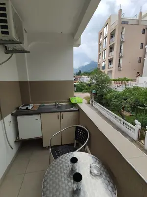 a small balcony with a table and a sink at Apartmani Vuković in Sutomore