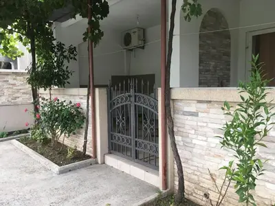a house with a gate on the side of it at Apartmani Vuković in Sutomore