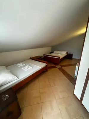 a room with two beds in a room with a floor at Guesthouse Vila Tamburic in Becici
