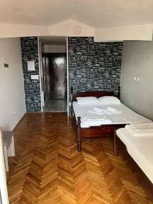 a bedroom with a bed and a brick wall at Guesthouse Vila Tamburic in Becici