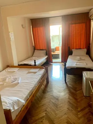 two beds in a room with a window at Guesthouse Vila Tamburic in Becici