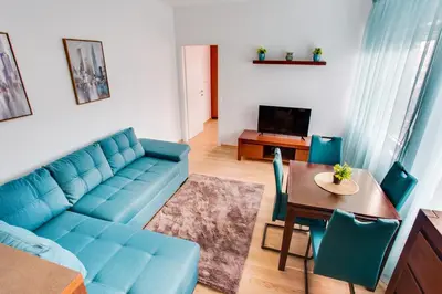 a living room with a blue couch and a table at Apartments LORA 13.Jula, 15 in Budva