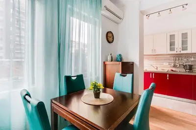 a kitchen and dining room with a wooden table and chairs at Apartments LORA 13.Jula, 15 in Budva