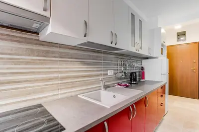 a kitchen with white cabinets and a sink at Apartments LORA 13.Jula, 15 in Budva