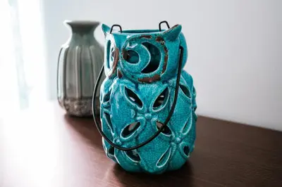 a green vase sitting on a table next to a silver vase at Apartments LORA 13.Jula, 15 in Budva