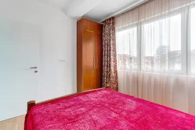 a bedroom with a pink bed and a window at Apartments LORA 13.Jula, 15 in Budva