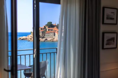 a room with a window with a view of the ocean at Hotel California by Aycon in Sveti Stefan