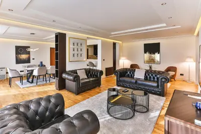 a living room with leather furniture and a dining room at Hotel California by Aycon in Sveti Stefan