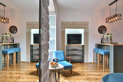 a waiting room with blue chairs and a table at P.S. Cattaro Apartments in Kotor