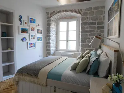 a bedroom with a bed with a stone wall at P.S. Cattaro Apartments in Kotor