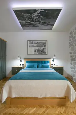 a bedroom with a large bed with blue pillows at P.S. Cattaro Apartments in Kotor