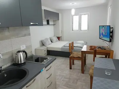 a room with a kitchen and a bedroom with a bed at Porto Njeguši A1 in Cetinje
