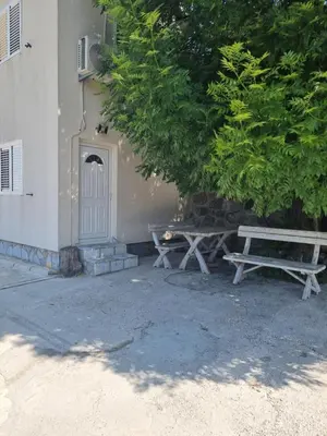 two picnic benches sitting next to a building at Porto Njeguši A1 in Cetinje