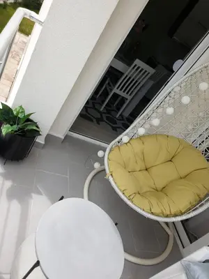 a wicker chair sitting on a balcony at Long Beach Apartment in Ulcinj