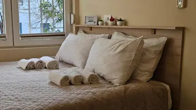 a bed with four pillows and towels on it at Cicki Apartments I - Renovated 2025 in Podgorica