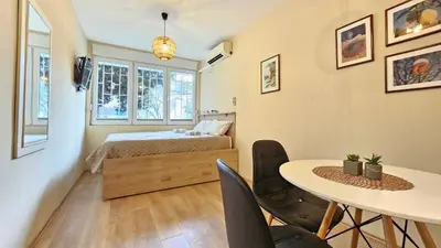 a bedroom with a bed and a table and chairs at Cicki Apartments I - Renovated 2025 in Podgorica