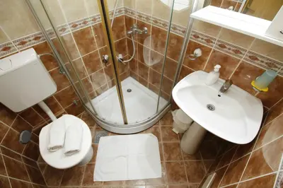 a bathroom with a shower and a toilet and a sink at Apartments Mitrovići Miločer in Sveti Stefan