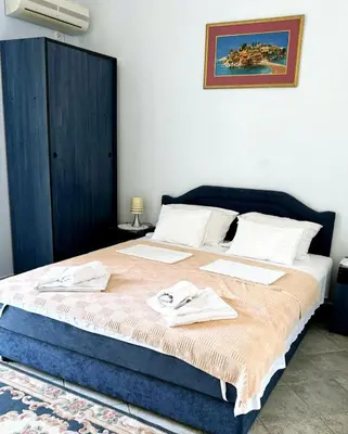 a bedroom with a large bed with towels on it at Apartments Mitrovići Miločer in Sveti Stefan